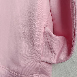 Close-up of a pink fabric texture with a light gray background