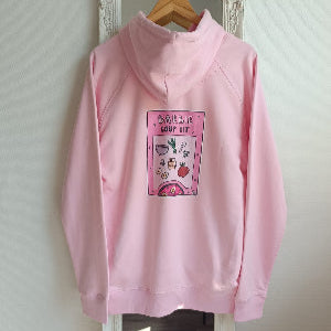 Pink hoodie with graphic design on a hanger against a white wall